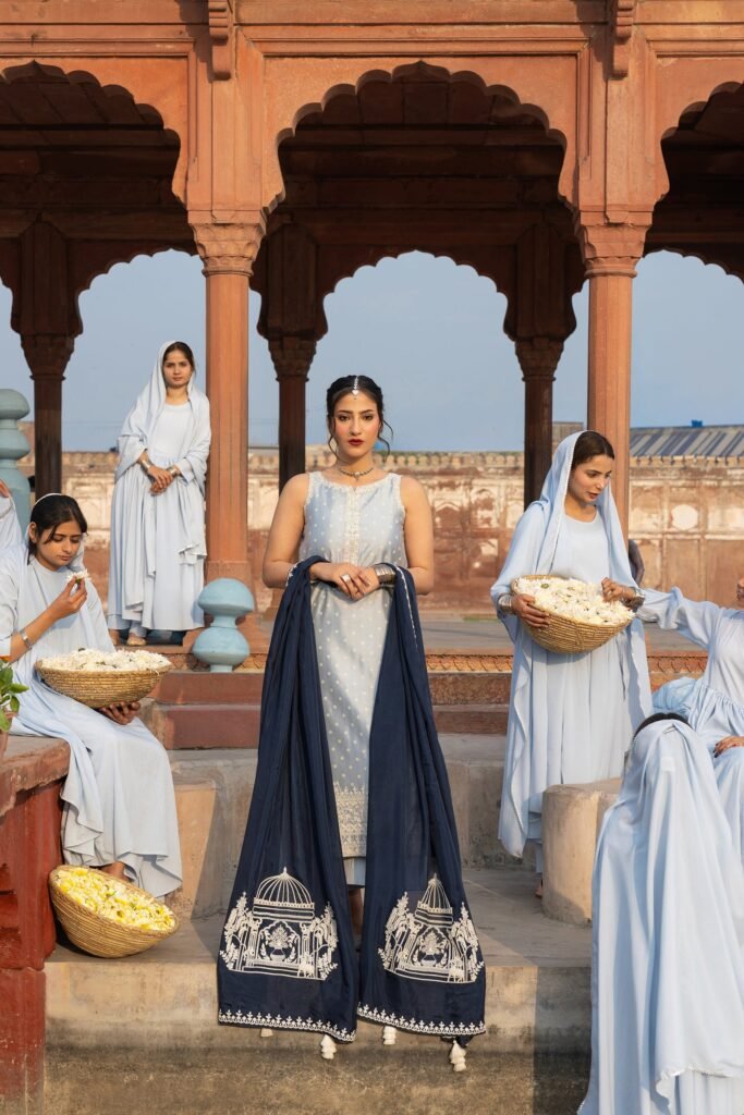 Models in pale blue Anaa Khan couture holding baskets of jasmine at a Mughal pavilion